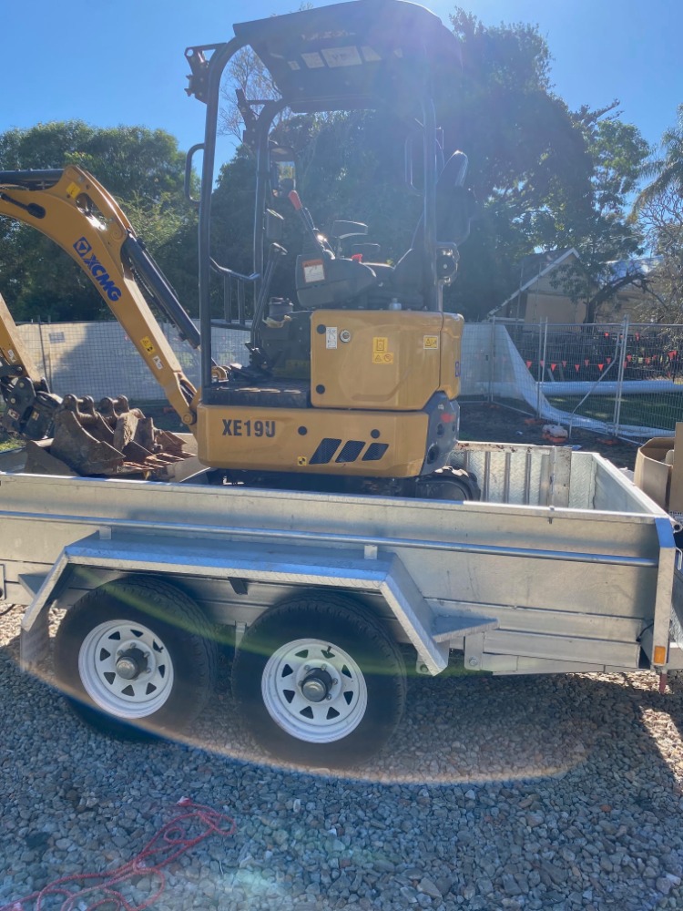 Mini excavator secured on a transport trailer